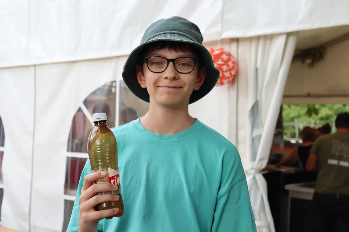 Ein Junge mit einer Rivella Flasche in der Hand